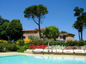 a swimming pool in front of a house with flowers at Tenuta Ponziani - Griffin's Resort in Morrano