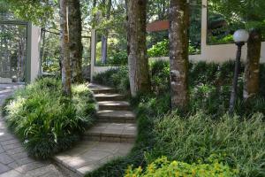 un jardín con árboles y una pasarela en LOCAR-IN GRAMADO - Residencial Maranello, en Gramado