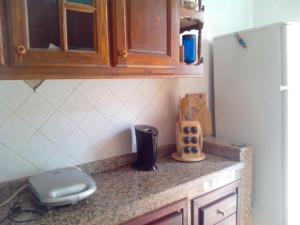 a kitchen counter with a sink and a refrigerator at Appartement high standing piscine jardin mer proche Mohammedia in Figuiq