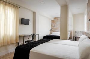 a hotel room with a bed and a tv at YIT Casablanca in Granada
