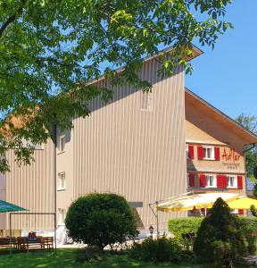 un gran edificio con un banco delante en Hotel Gasthof Adler, en Lingenau