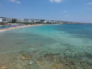 a view of a beach with people in the water at Karousos Beach Rooms in Ayia Napa