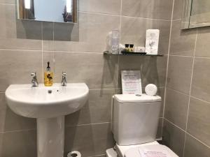 a bathroom with a white sink and a toilet at Glendale Guest House in Penrith