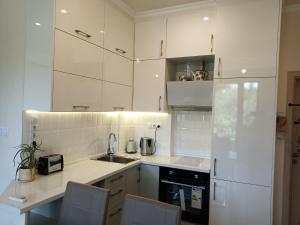 - une cuisine blanche avec des placards blancs et un évier dans l'établissement Sea Garden Apartment, à Varna