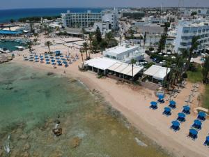 an aerial view of a beach with chairs and umbrellas at Karousos Beach Rooms in Ayia Napa