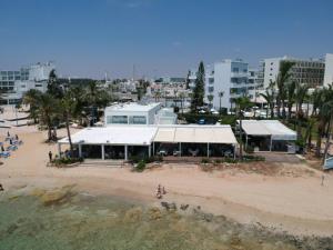 a building on the beach next to a beach at Karousos Beach Rooms in Ayia Napa