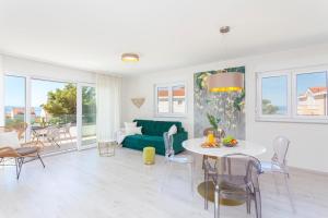 a living room with a green couch and a table at Fiori Boutique Apartment in Promajna