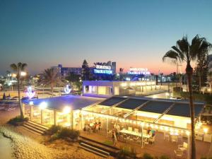 a building with lights in a city at night at Karousos Beach Rooms in Ayia Napa
