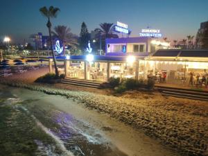 a restaurant on the beach at night at Karousos Beach Rooms in Ayia Napa