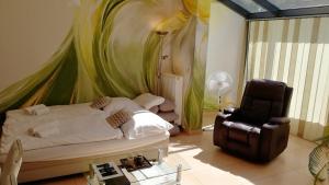 a bedroom with a bed and a chair in it at Apartmány Duo in Dačice
