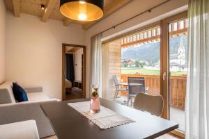 a living room with a table and a large window at App. Pedagà - Ciasa Lavarella in San Vigilio Di Marebbe