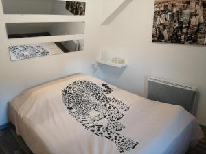 Un dormitorio con una manta de leopardo en una cama en Magnifique gîte plein centre de Sélestat, en Sélestat