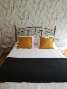 マラガにあるApartamentos Centro Malagaのベッドルーム1室(黄色い枕のベッド1台付)