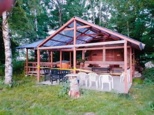 a log cabin with a table and chairs in the grass at Majatalo Tyrni in Nakkila