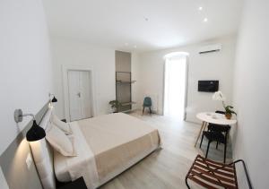 una camera bianca con letto e tavolo di b&b boutique suite bari a Bari
