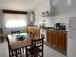 een keuken met een tafel en stoelen en een koelkast bij APARTAMENTOS CAMIÑO DO RIO in O Grove