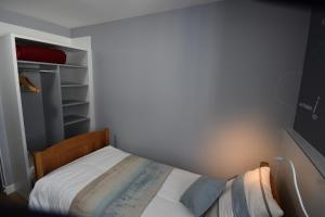a small bedroom with a bed and a closet at Hotel Atlantique in Le Palais