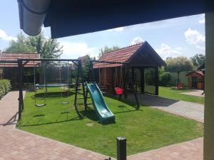 a playground with a slide in a yard at Penzion Kozak B&B in Sebedražie