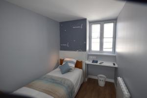 a small bedroom with a bed and a window at Hotel Atlantique in Le Palais