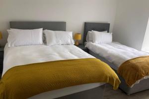 two beds sitting next to each other in a bedroom at Rooneys @ Ballymagreehan Explore and Unwind in Castlewellan