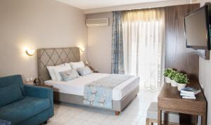1 dormitorio con cama, sofá y TV en Hotel Olga en Sarti