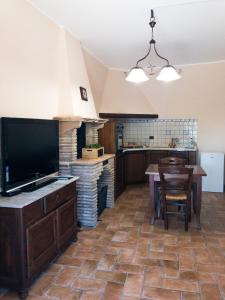 a kitchen with a large flat screen tv and a table at Casa Vacanze La Piazzetta del Castello in Montecalvello