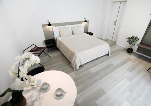 una camera con un letto bianco e un tavolo di b&b boutique suite bari a Bari