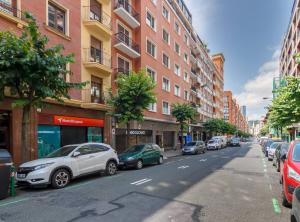 una strada cittadina con auto parcheggiate sul lato della strada di Urban Class apartament by the urban hosts a Bilbao