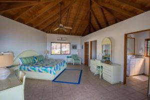 a bedroom with a bed and a desk and a kitchen at LOBLOLLY in Virgin Gorda