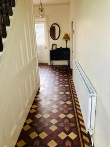 a hallway with a tile floor and a stairway at Sherwood House in Matlock