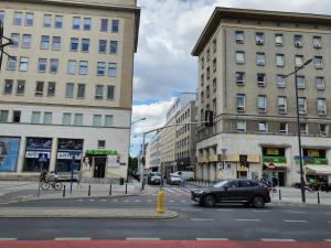 un'auto che guida lungo una strada cittadina con edifici di Jasna Hotelik a Varsavia