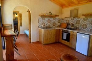 a kitchen with a stove and a counter top at Cozy house in beautiful valley, close to the beach in Odeceixe +10 photos