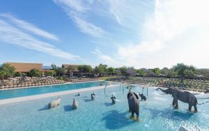 un grupo de pingüinos y caballos en una piscina en Camping & Resort Sangulí Salou en Salou
