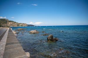 a body of water with rocks in the water at La Casetta Azzurra NAXOS in Giardini Naxos