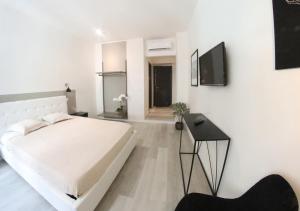 een witte slaapkamer met een bed en een tafel bij b&b boutique four rooms bari in Bari
