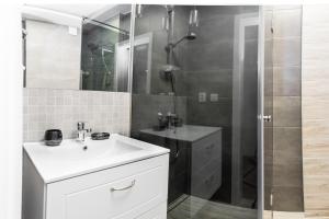 a bathroom with a white sink and a shower at Pomeranian House in Gdańsk