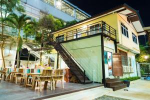 a building with a staircase next to a table and chairs at NTY Hostel Near Suvarnabhumi Airport in Bangkok