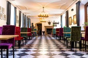 a room with tables and chairs and a checkerboard floor at Hotel Deutschherrenhof in Zeltingen-Rachtig