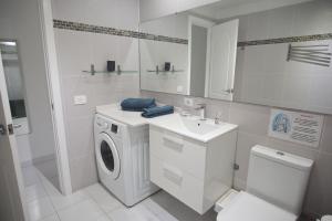 a white bathroom with a washing machine and a sink at Departamento Maria in Puerto del Carmen