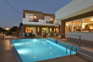 a house with a swimming pool in front of a house at Okeanis II in Kato Daratso +13 photos