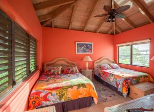 two beds in a room with orange walls and windows at SANDCASTLE in Virgin Gorda +12 photos