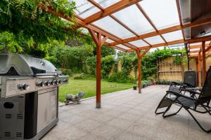 an outdoor patio with a grill and a smoker at La Hacienda in Vilvoorde