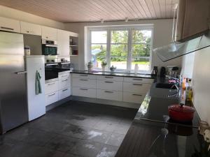 uma cozinha com electrodomésticos brancos e uma grande janela em SLEEPIND em Aabenraa