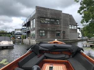 a boat in the water in front of a building at The Boathouse with boat in Aalsmeer