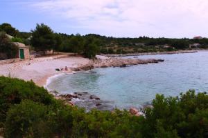 a beach with people on the sand and water at Apartments Tonka in Primošten