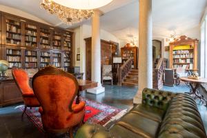 a living room with a couch and chairs in a library at Ronco Dell'Abate - Lake Como Relais B&B in Como