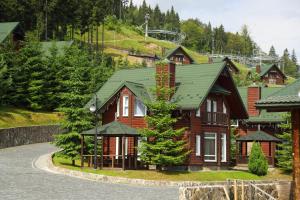 a large wooden house with a green roof at Bukovel Hotel in Bukovel