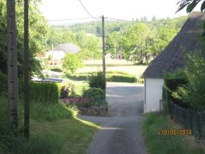 a small road with a small house and a driveway at Hotel Le Commerce in Neuville