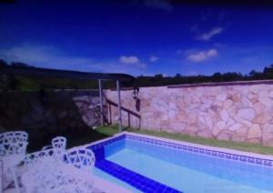 a small swimming pool in a yard with a stone wall at Pousada dos Bandeirantes in Ouro Preto