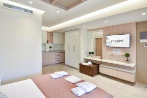 a bedroom with a bed and a tv on a wall at On Board Luxury Studios in Sarti